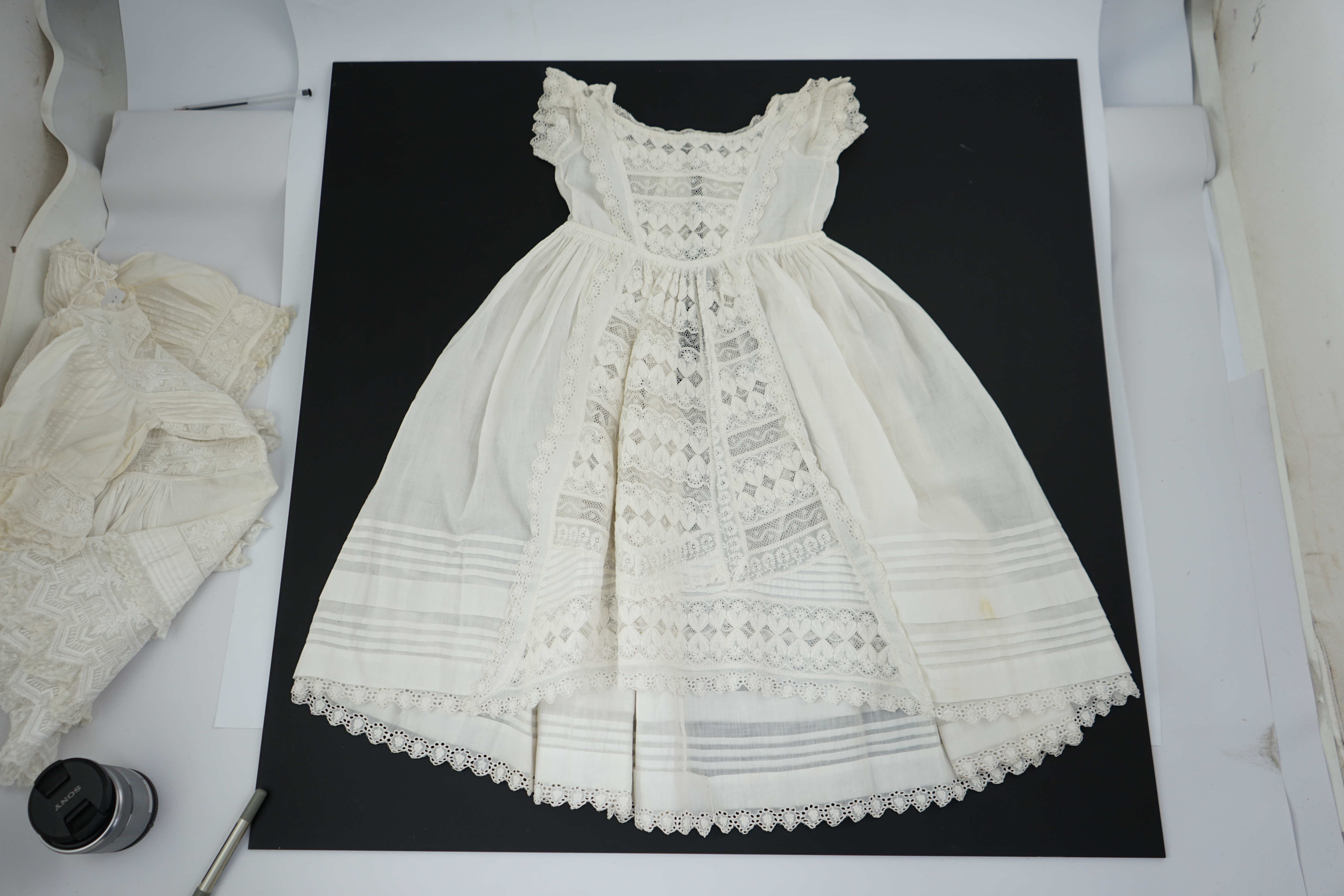 Two unusual 19th century intricately white worked children’s dresses, one hand worked with fine panels of white work, feather stitching and tucking, edged and inserted with hand made Valenciennes lace, the other worked i